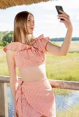 Karianne Bending Over The Railing With A Smile